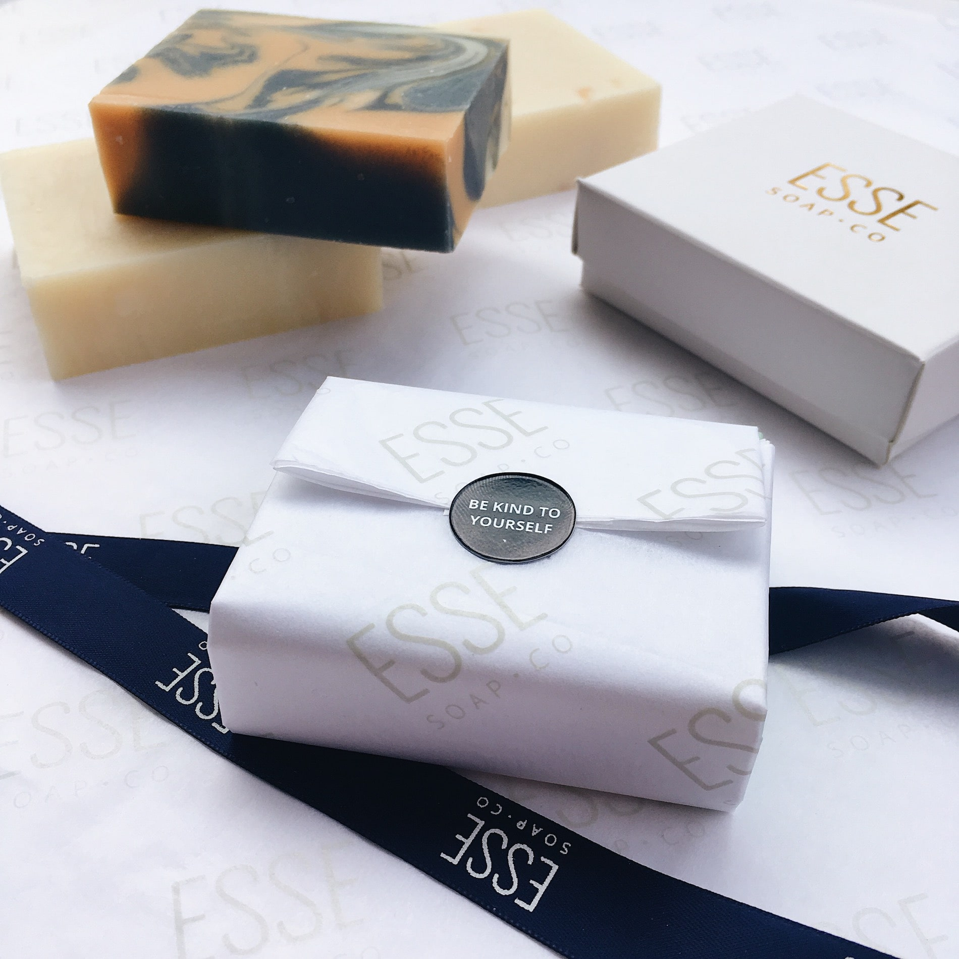 close-up of soap wrapped up in branded white custom tissue paper with a customized sticker