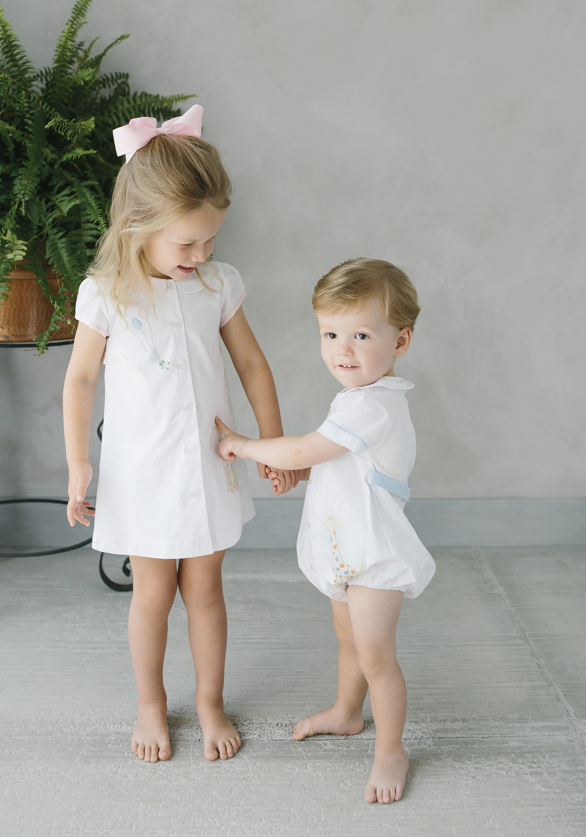 Boy and girl dressed in white smocks
