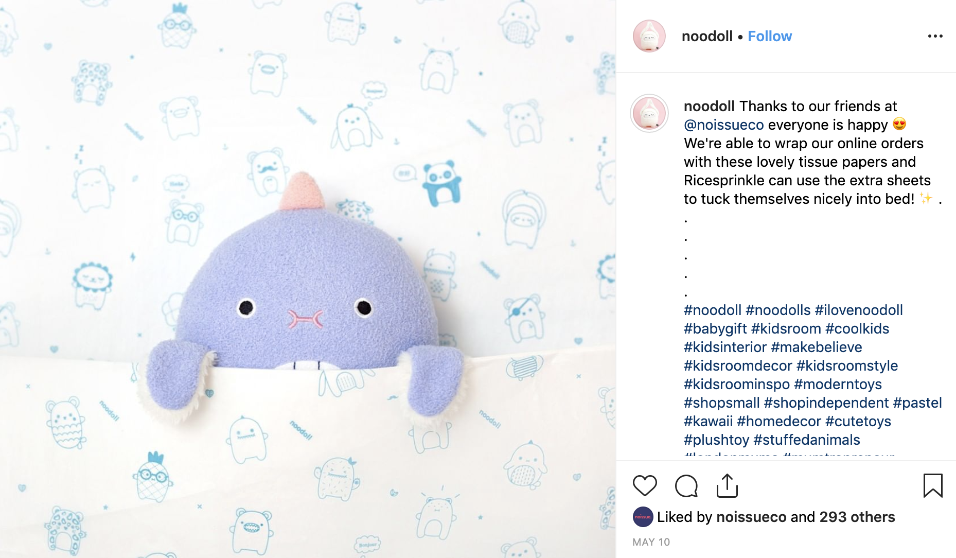 Noodoll toy tucked up in custom tissue paper like blankets