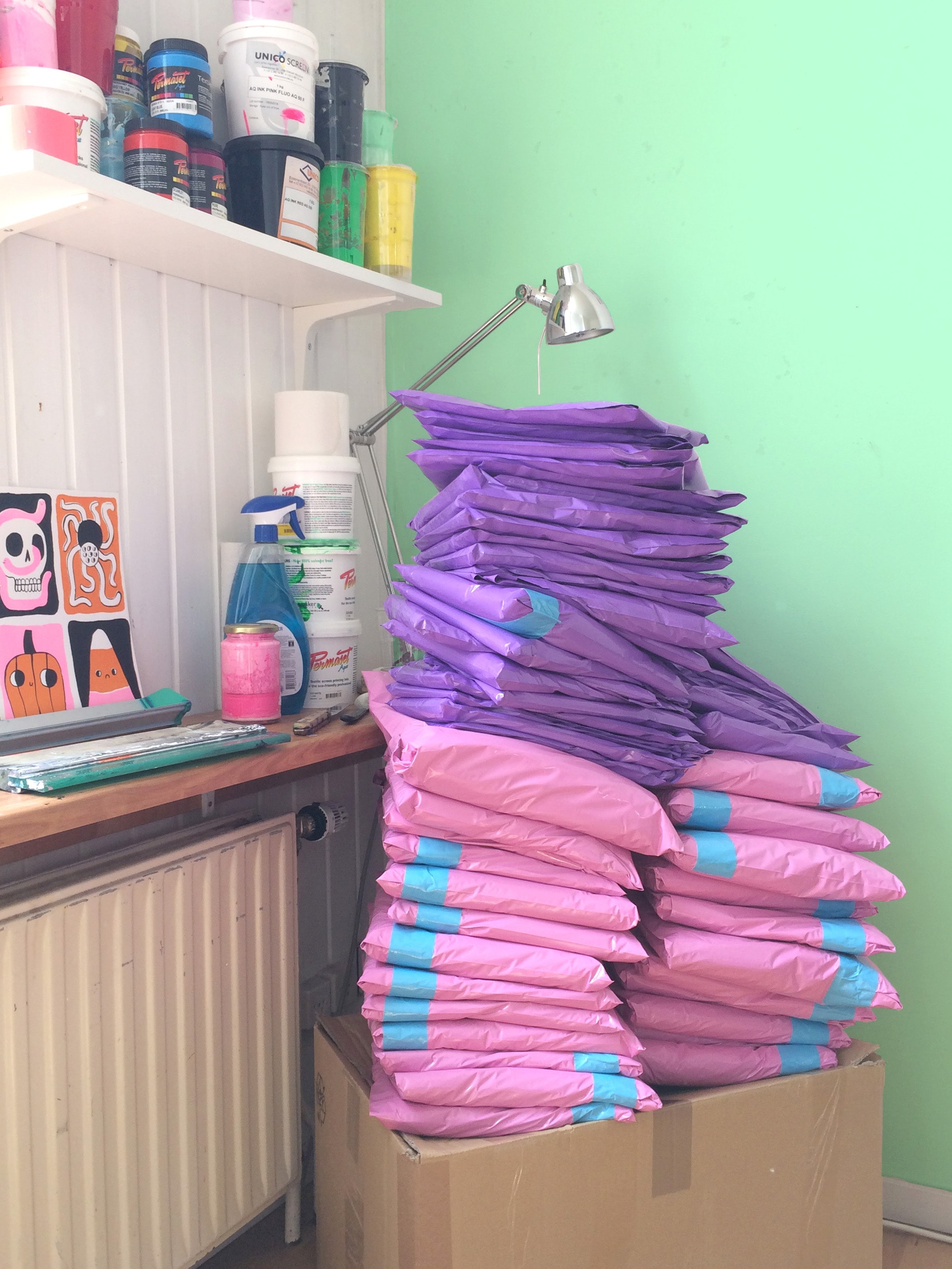Pile of pink and purple mailer bags on desk