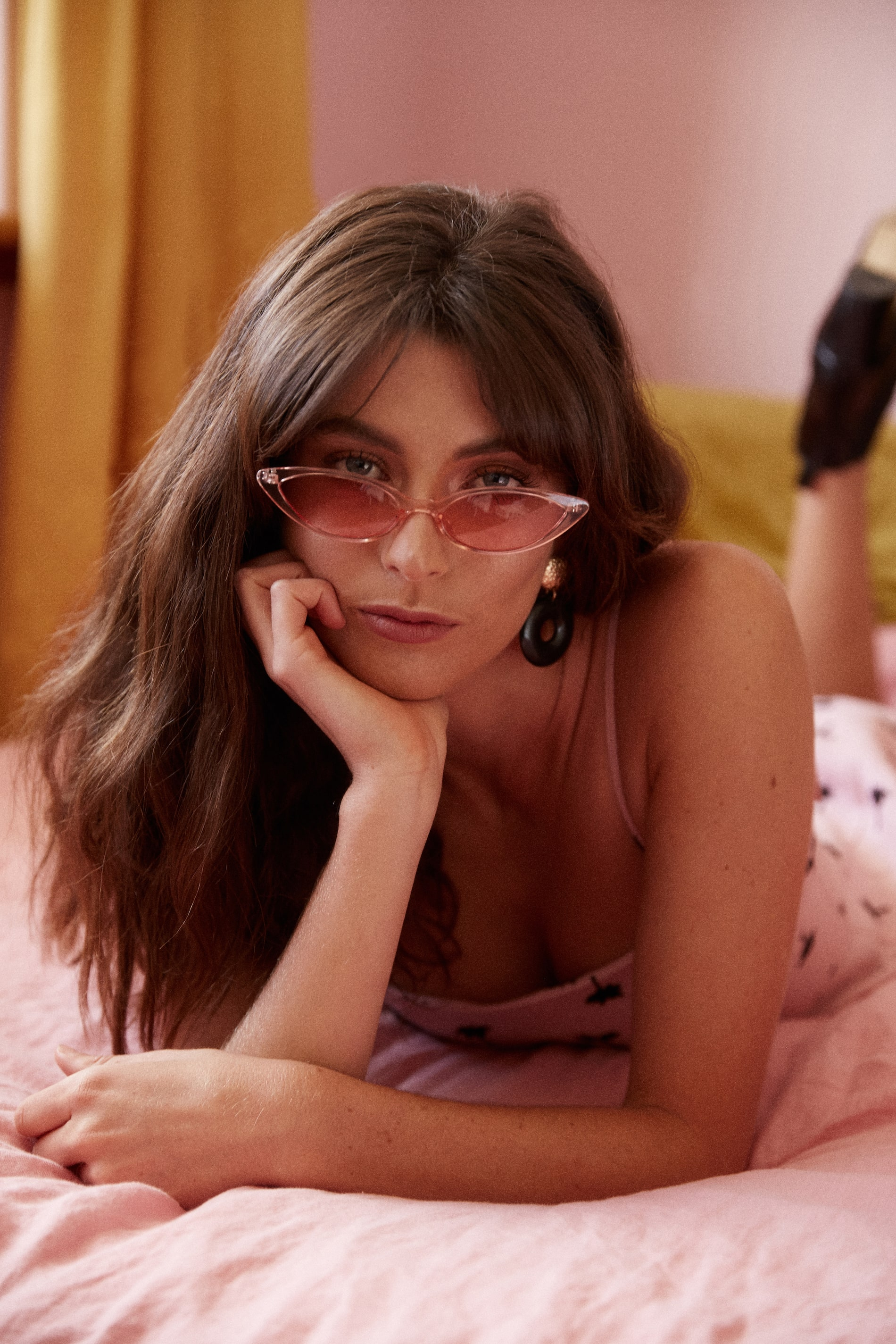 Model wearing tinted pink sunglasses